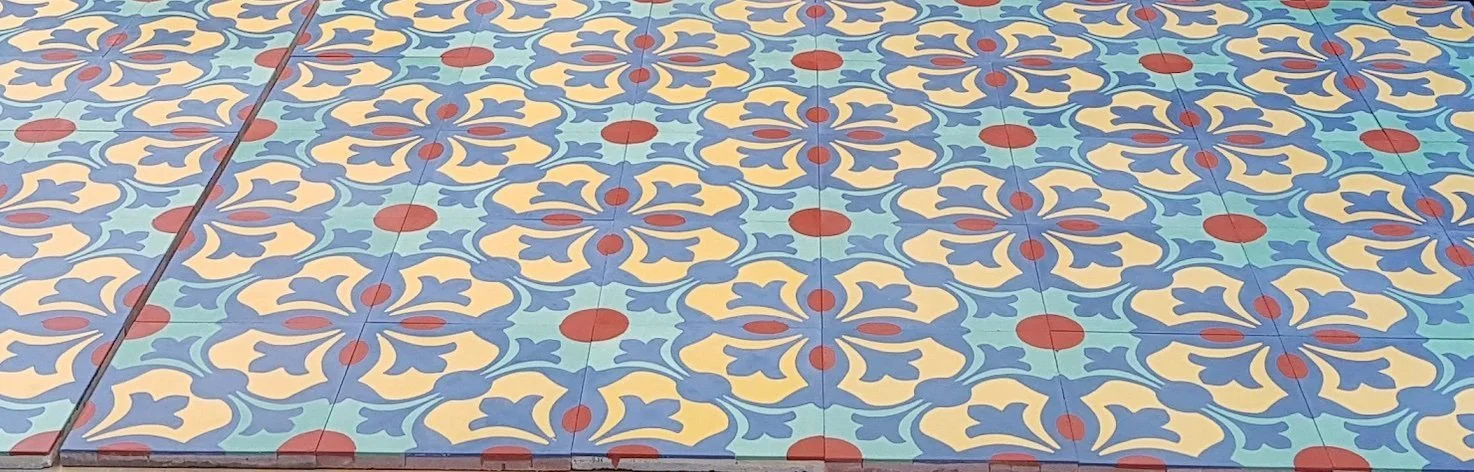 Carrelage de sol avec motif coloré en bleu, jaune, rouge et vert.