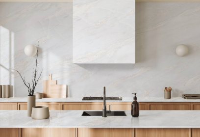 Cuisine minimaliste avec plan de travail en marbre, vaisselle, et éléments décoratifs naturels en bois et céramique.