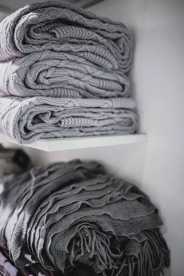 Effective retail product markdowns kaboompics_Grey woolen fabric stacked on shelves 2.jpg