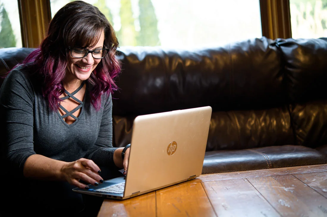 NYC Branded Lifestyle Portrait Tricia Kallmeyer working on laptop smiling