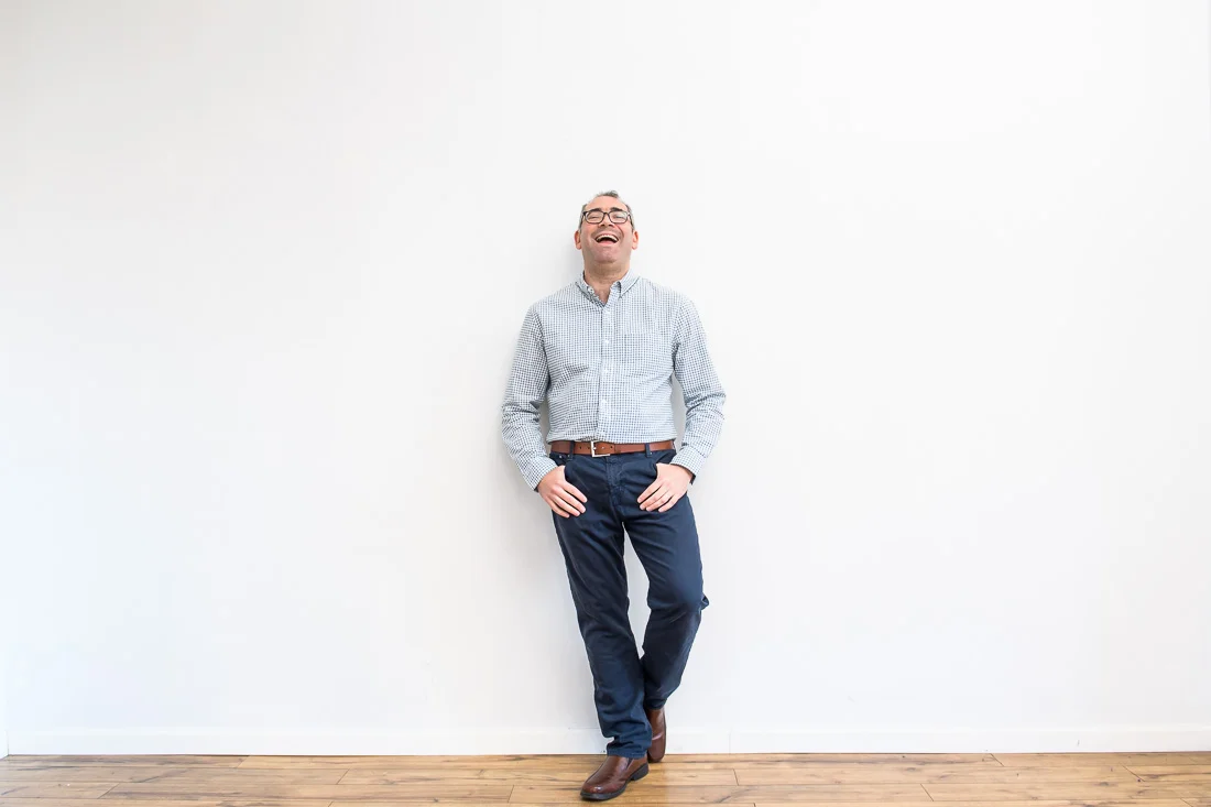 speaker connector thought leader Michael Roderick branded lifestyle portrait leaning on wall smiling