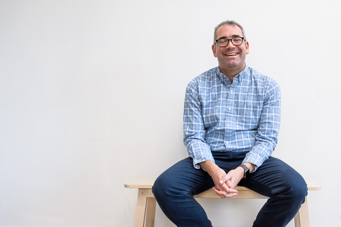 speaker connector thought leader Michael Roderick branded lifestyle portrait sitting on bench smiling