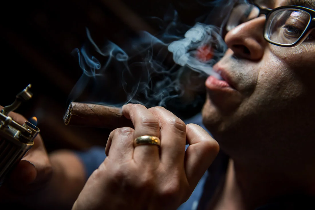 NYC Branded Lifestyle Portraits Cigar Merchant Luis Paredes puffing cigar smoke