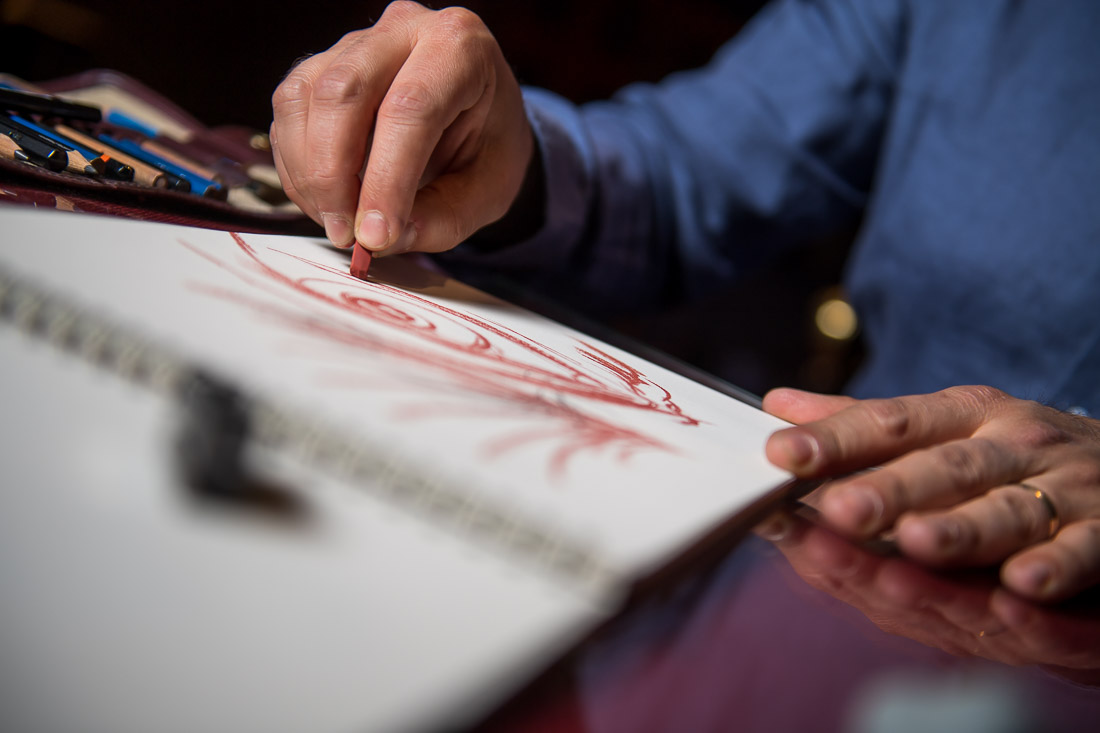 NYC Branded Lifestyle Portraits Cigar Merchant Luis Paredes creating a charcoal sketch in pad