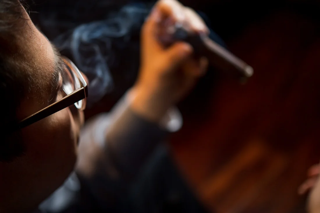 NYC Branded Lifestyle Portraits Cigar Merchant Luis Paredes holding a cigar in his hands