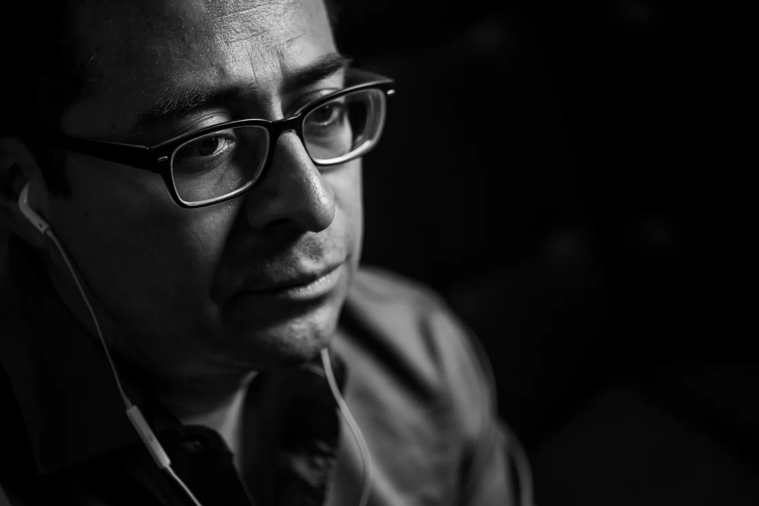 NYC Branded Lifestyle Portraits Cigar Merchant Luis Paredes thinking to himself with earbuds in