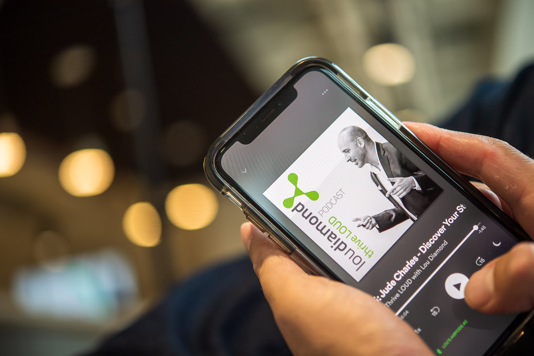 NYC Branded Lifestyle Portraits Speaker Thrive Lou Diamond looking at podcast on phone