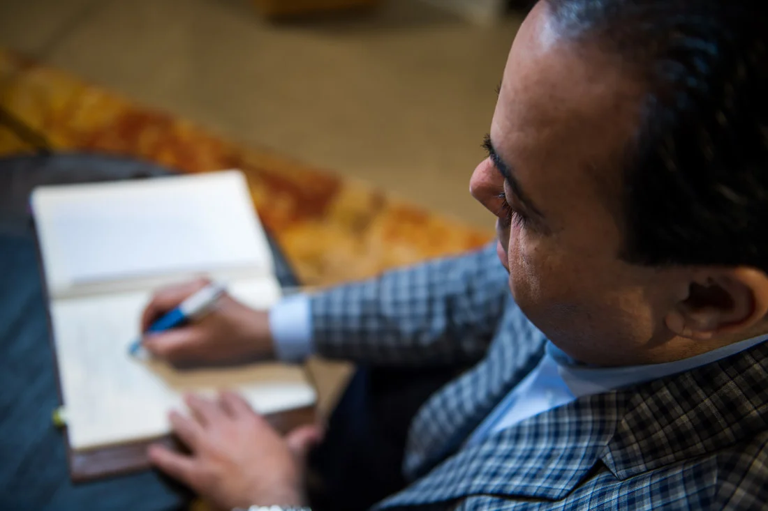 NYC Branded Lifestyle Portraits Sales Executive Speaker Anthony Chaine writing notes in book