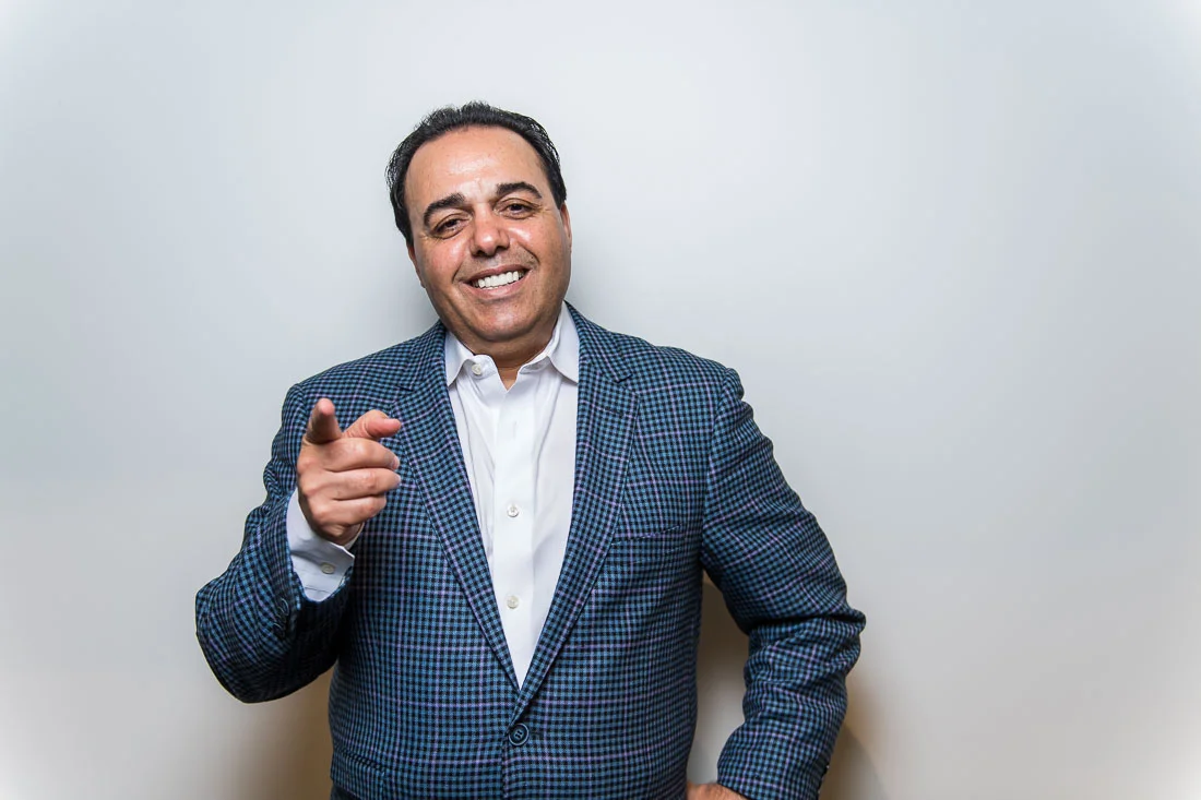 NYC Branded Lifestyle Portraits Sales Executive Speaker Anthony Chaine smiling and pointing to camera