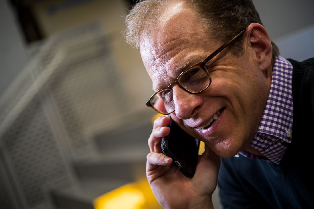 NYC Branded Lifestyle Portraits speaker author coach Michael O'Brien on phone, smiling