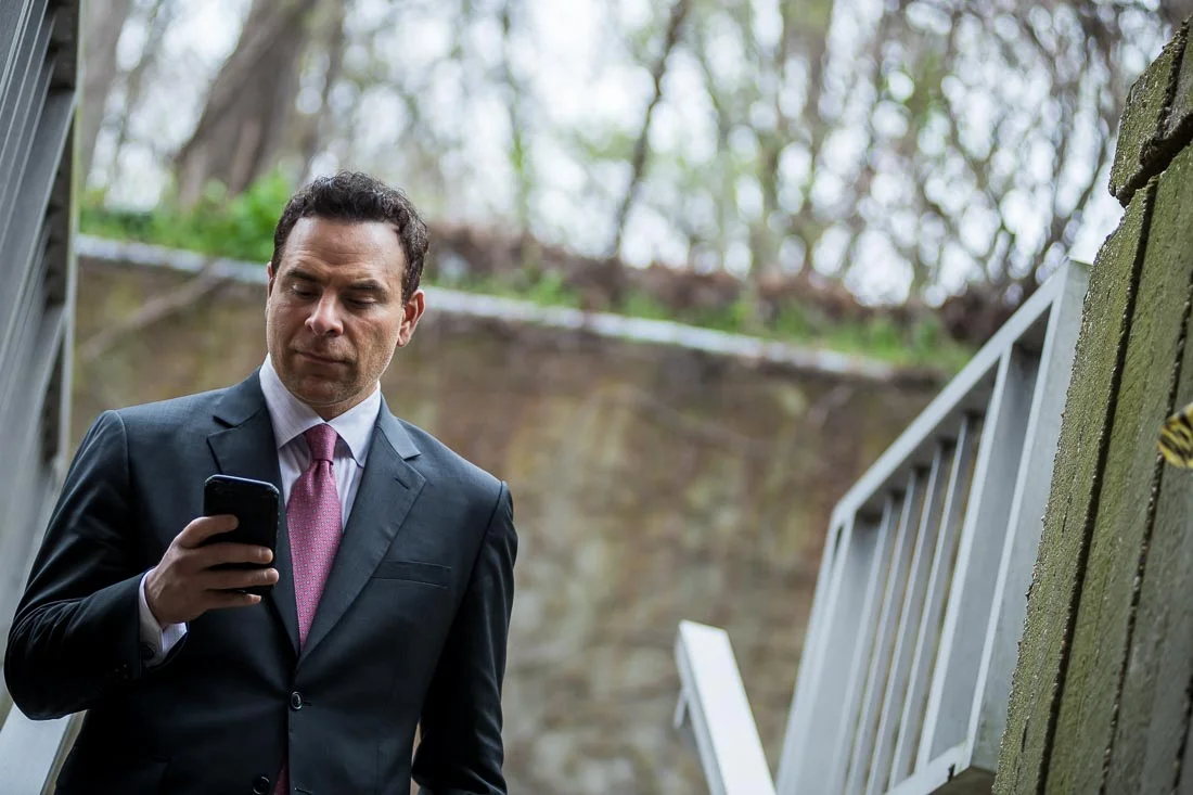NYC Branded Lifestyle Portraits Doctor Author Dr. Brian Lima walking while looking thru phone