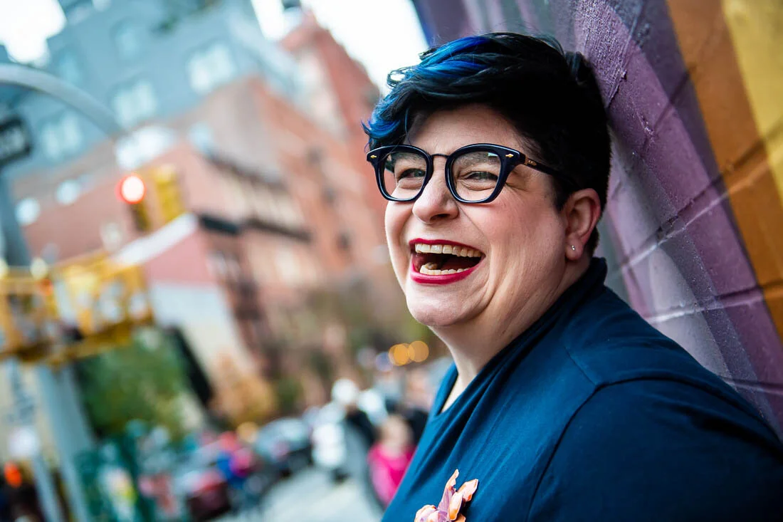 NYC Branded Lifestyle Portraits speaker Jess Pettitt laughing while leaning against a wall