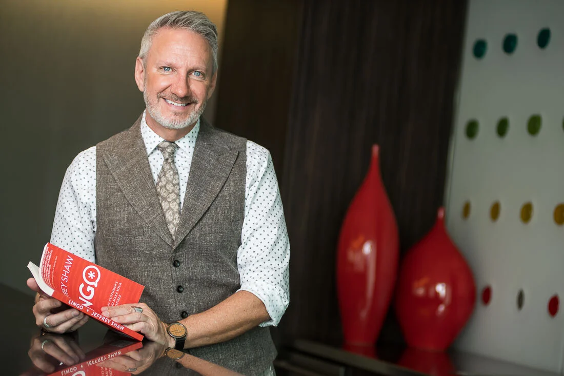 NYC branded lifestyle portrait Speaker Lingo Author Jeffrey Shaw holding his book and smiling