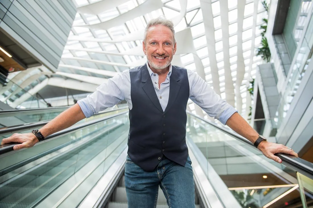 NYC branded lifestyle portrait Speaker Lingo Author Jeffrey Shaw on escalator smiling