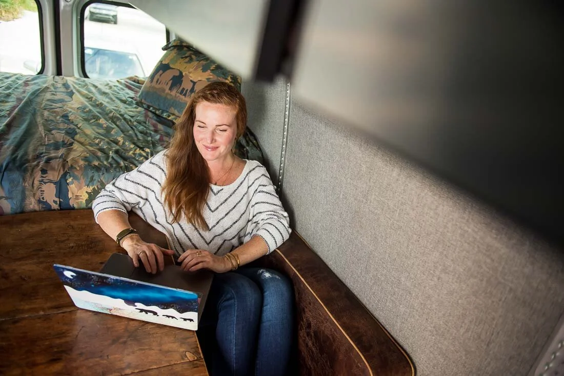 NYC branded lifestyle portrait Speaker Mary Rooney working on her laptop in van
