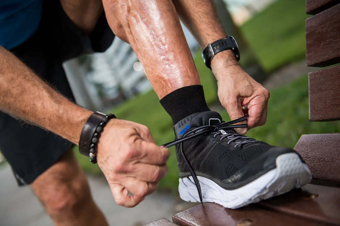 NYC Branded Lifestyle Portrait Howie Doin It Howie Kra tying shoelace on bench