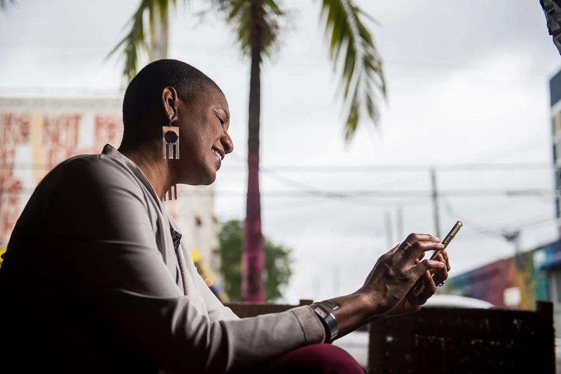 NYC branded lifestyle portrait Speaker Author Denise Jacobs working on her phone