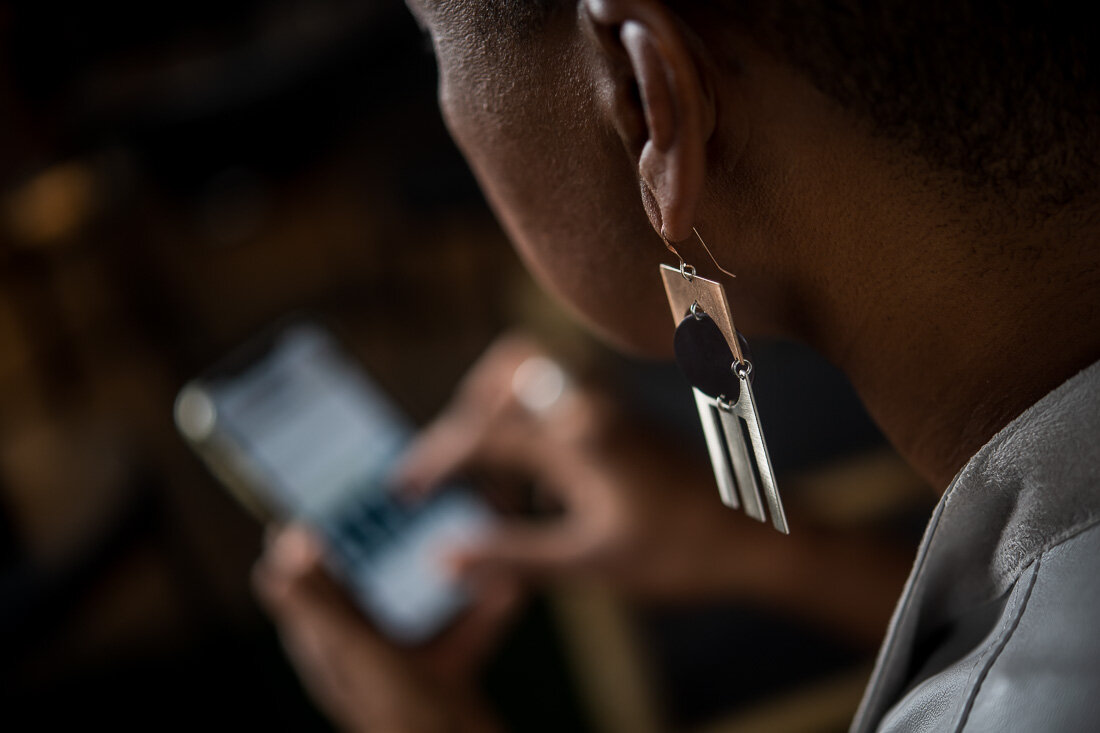 NYC branded lifestyle portrait Speaker Author Denise Jacobs working on phone in coffee shop