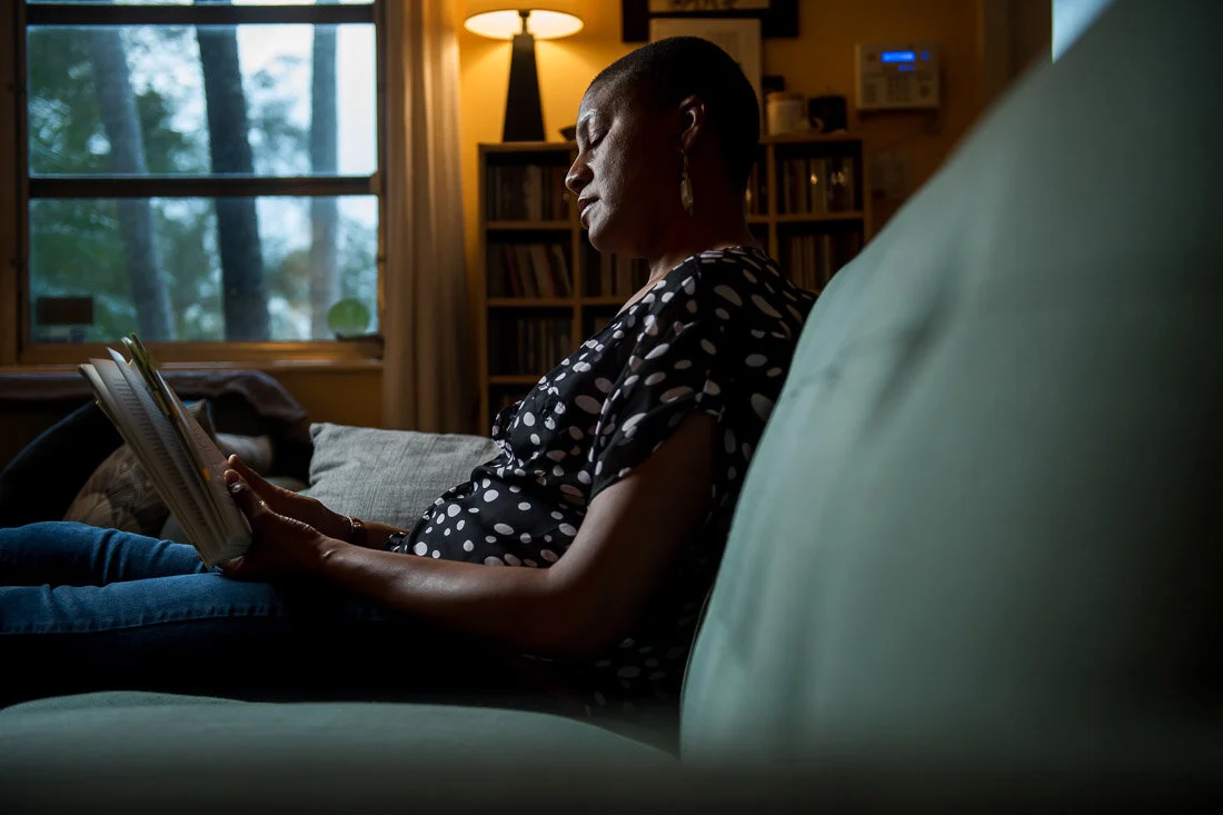 NYC branded lifestyle portrait Speaker Author Denise Jacobs reading a book on couch