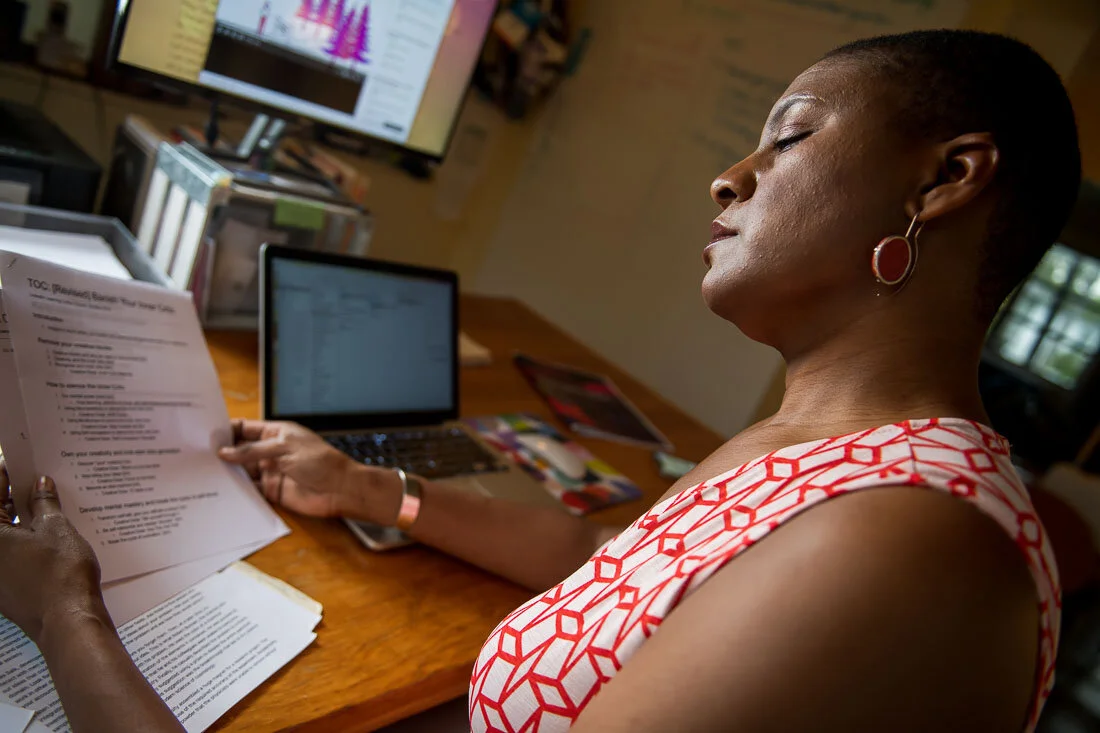 NYC Branded lifestyle portrait Speaker Author Denise Jacobs reading notes at her desk