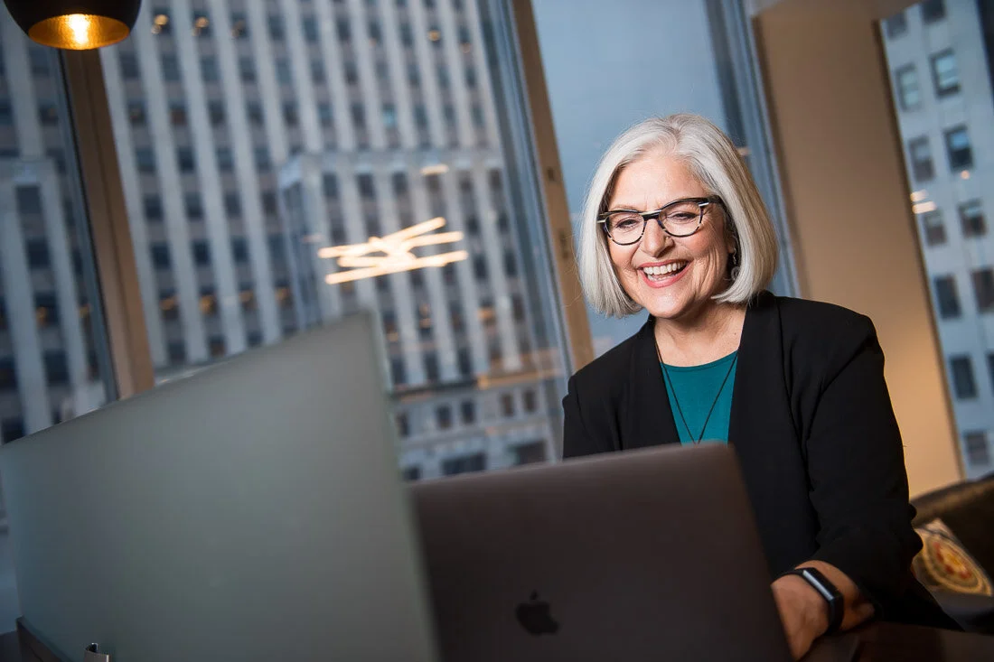 NYC Personal Branding Photography Speaker Trainer Janet Neal working on laptop smiling