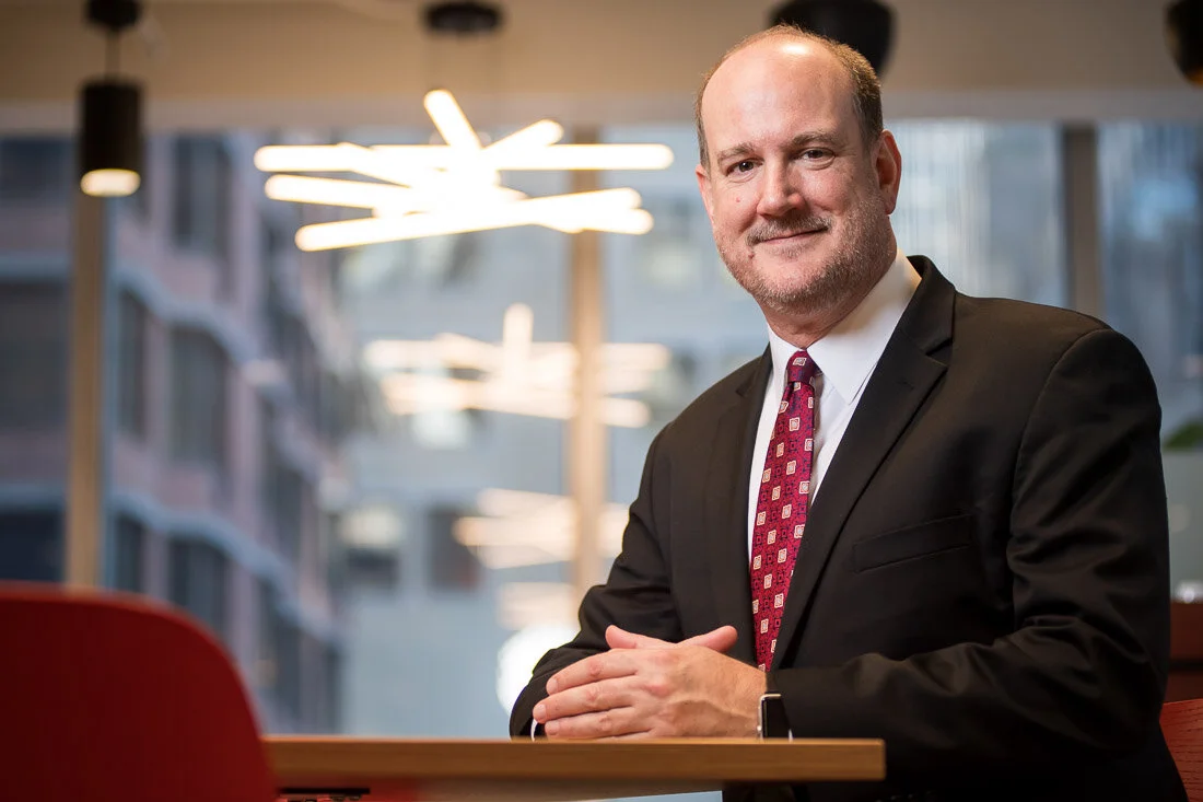 NYC personal branding photography Speaker Consultant Ken Blackwell smiling while sitting at a table
