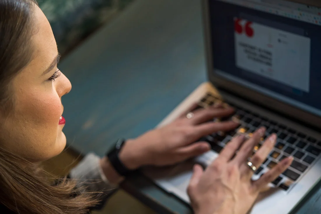 NYC personal branding photo Speaker Author Melanie Deziel typing on her laptop