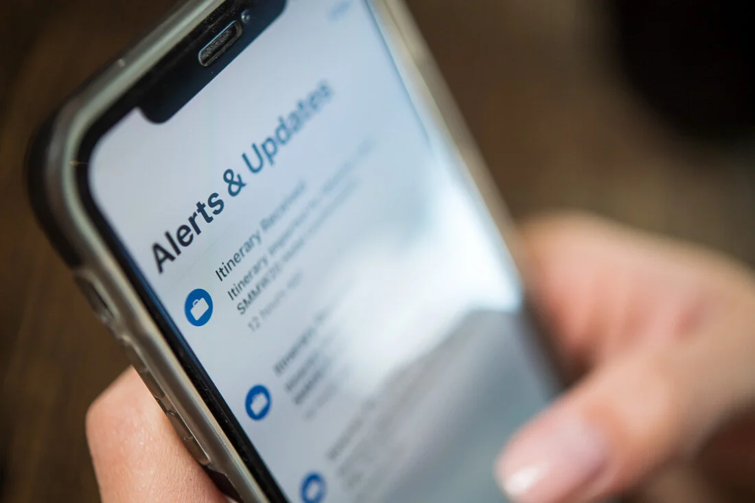 NYC personal branding photo Speaker Author Melanie Deziel looking through alerts and updates on her phone