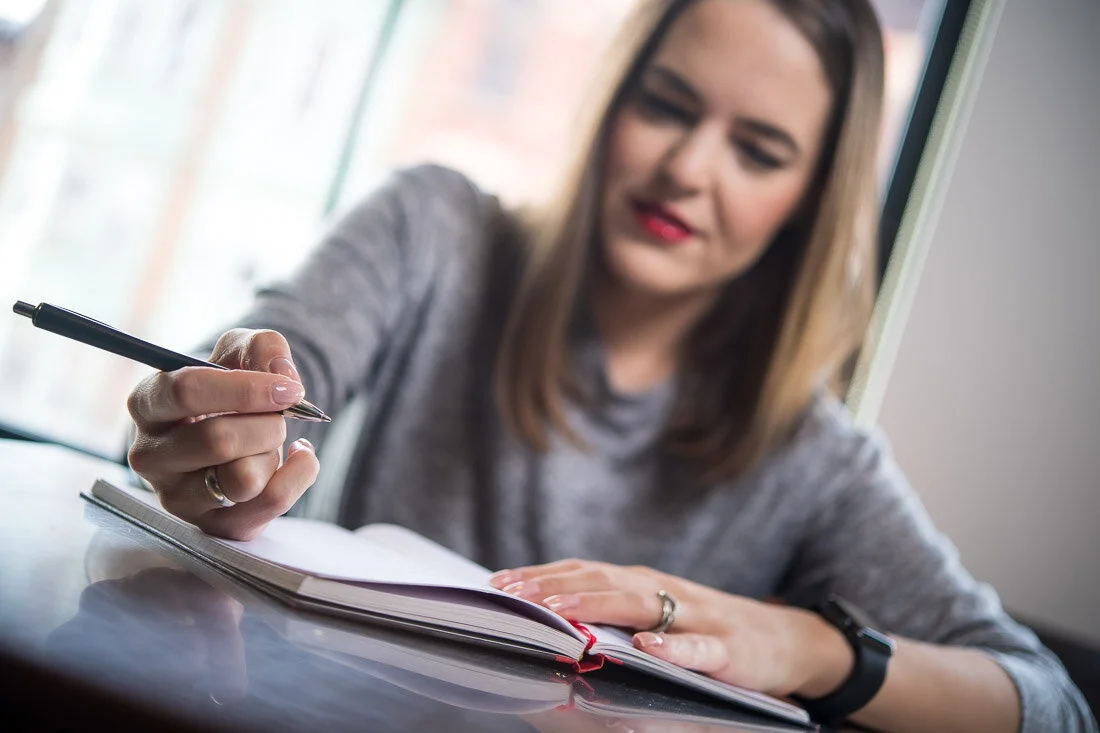 NYC personal branding photo Speaker Author Melanie Deziel reviewing notes in notebook