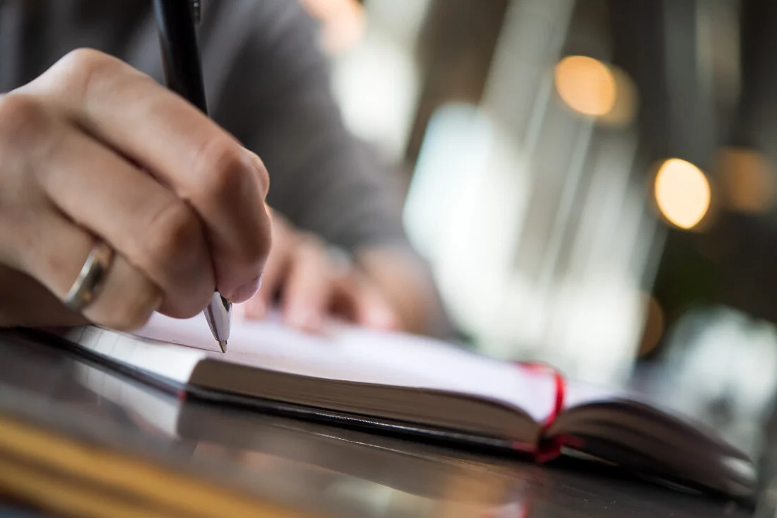 NYC personal branding photo Speaker Author Melanie Deziel closeup her hand writing notes in book