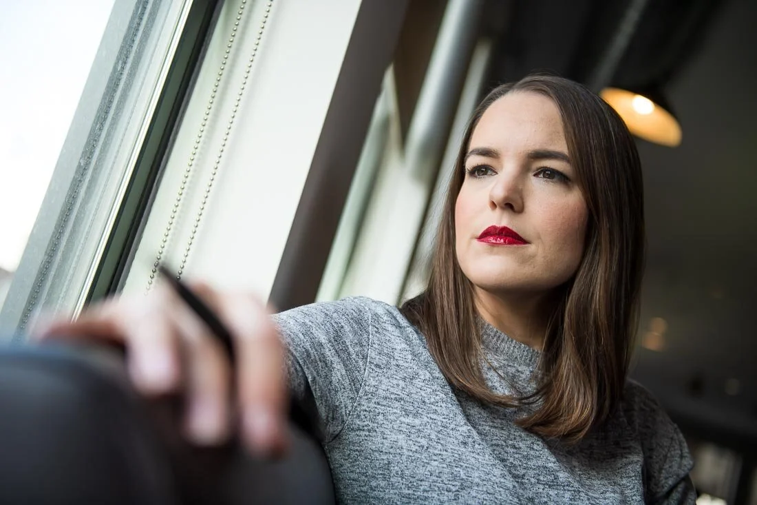 NYC personal branding photo Speaker Author Melanie Deziel looking out the window and reflecting