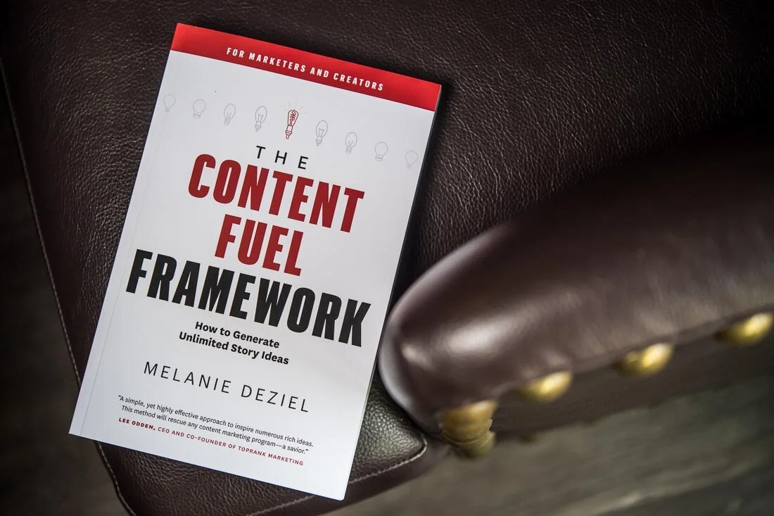 NYC personal branding photo Speaker Author Melanie Deziel book on a leather chair