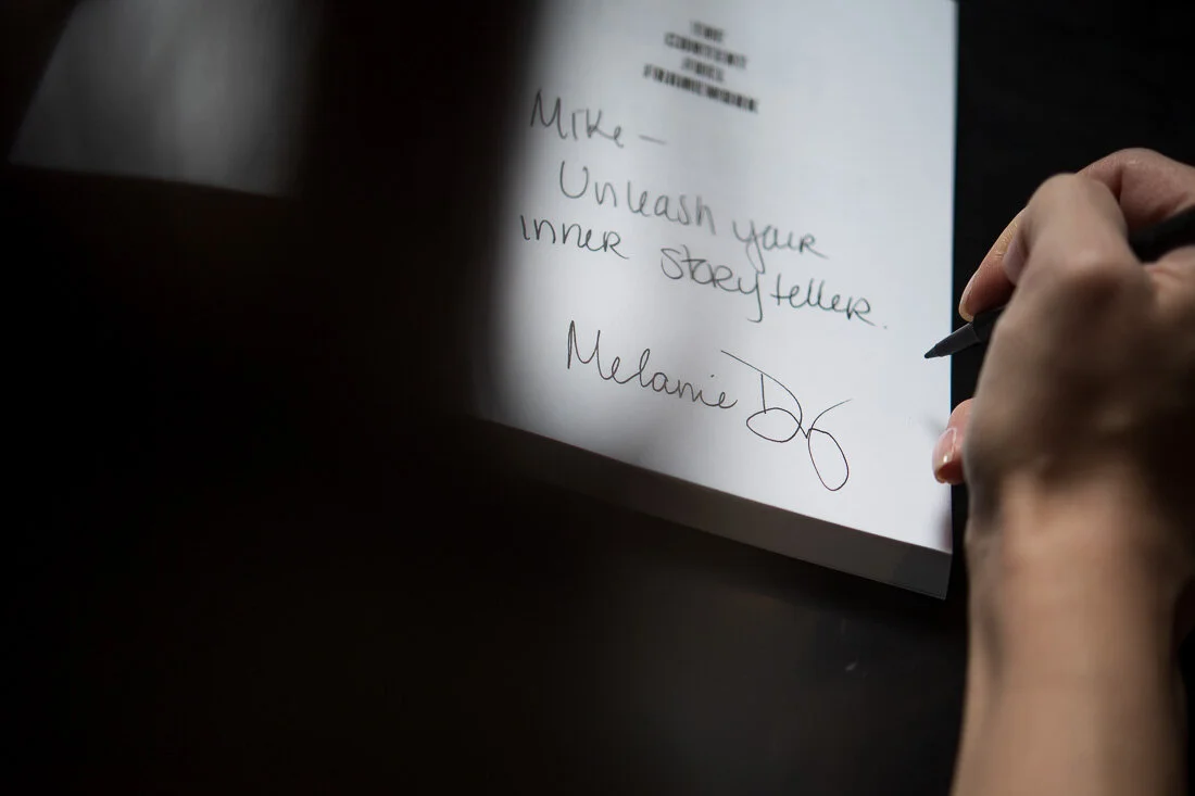 NYC personal branding photo Speaker Author Melanie Deziel signing a copy of her book