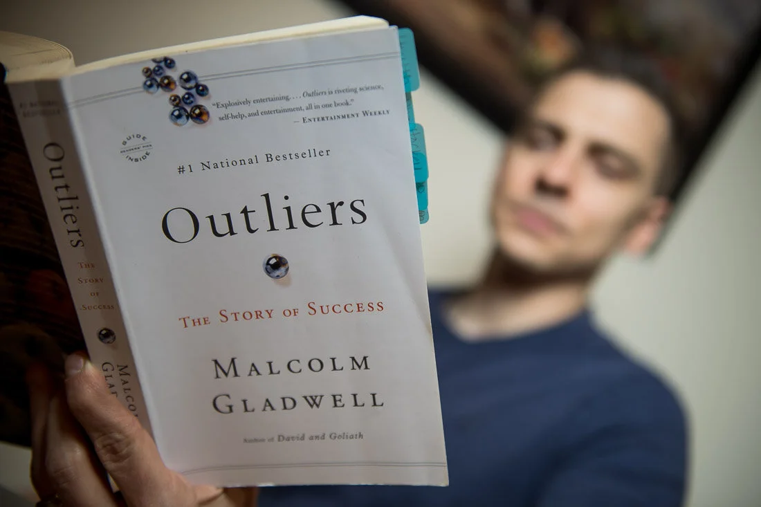 NYC Personal Brand Photography Webinar Consultant Joel Erway reading outliers book