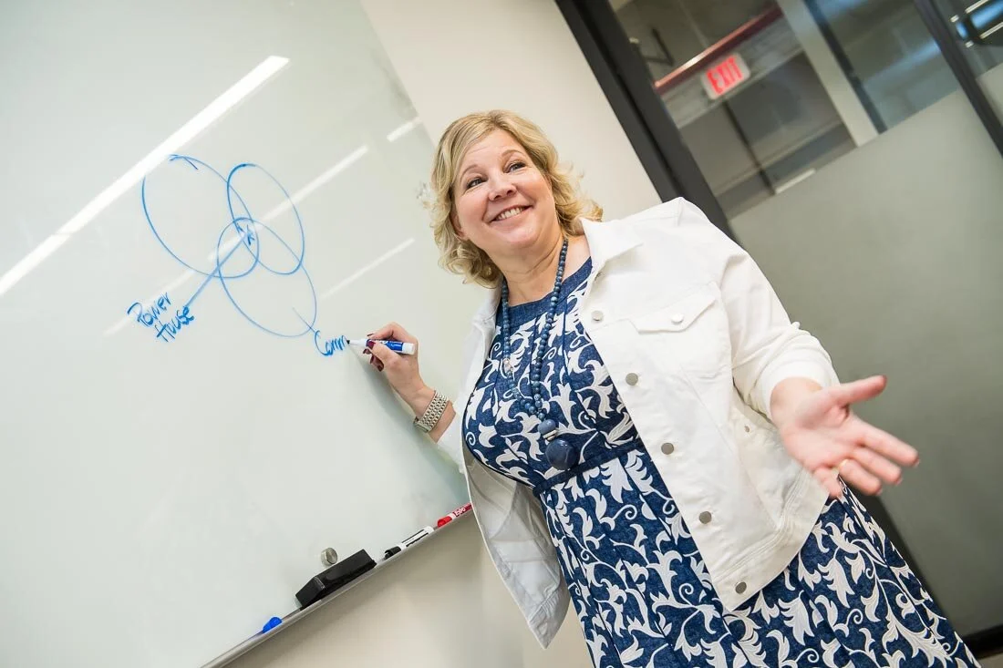 NYC Branded Lifestyle Portrait Speaker Lisa Haen answering a question while writing on board