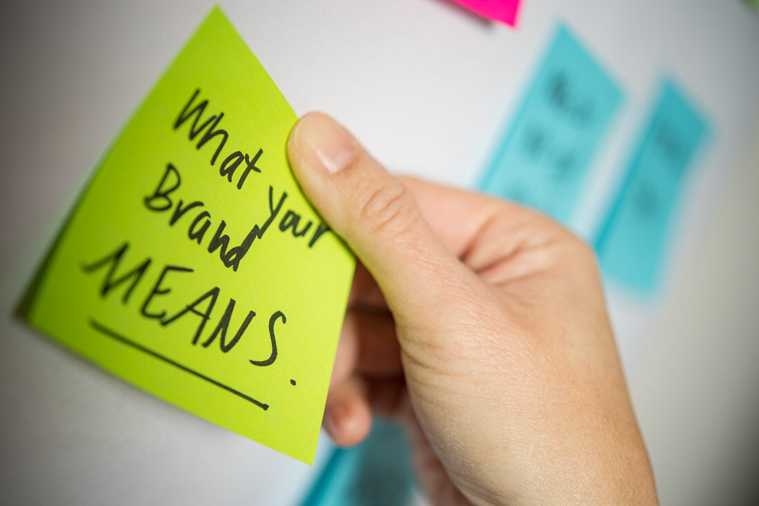 NYC branded lifestyle portraits speaker writer Terri Trespicio hand posting a note on idea wall