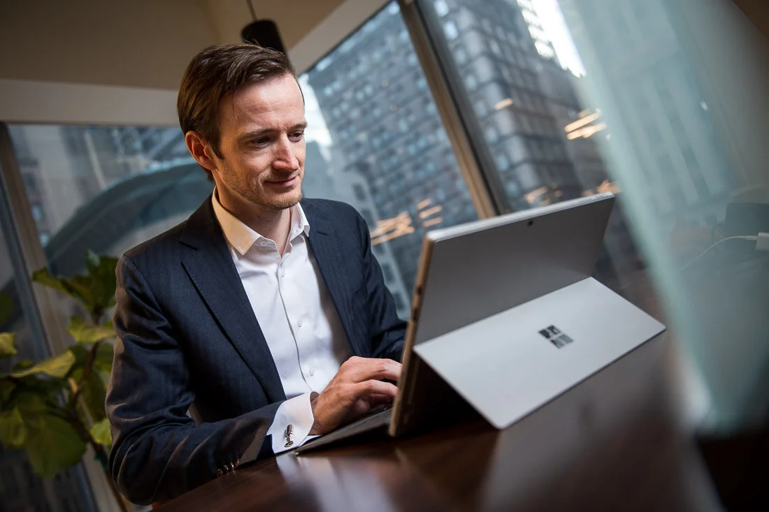 NYC Personal Branding Photography Humorist Drew Tarvin working on  laptop