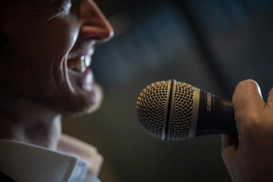 NYC Personal Branding Photography Humorist Drew Tarvin smiling while holding microphone
