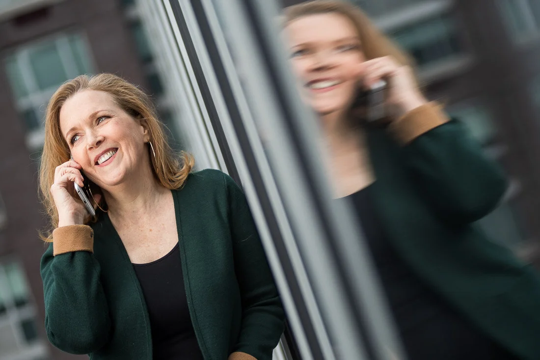 NYC personal branding photography Speaker Facilitator Jeanne Stafford talking on the phone smiling