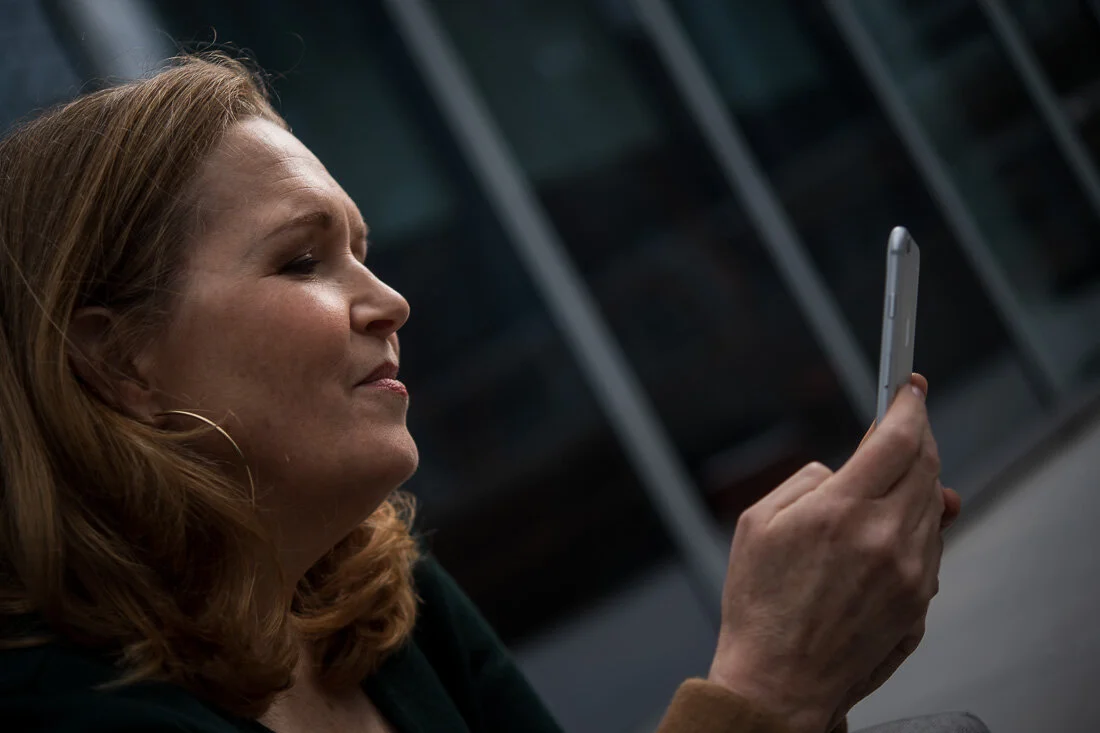NYC personal branding photography Speaker Facilitator Jeanne Stafford reading notes on her phone