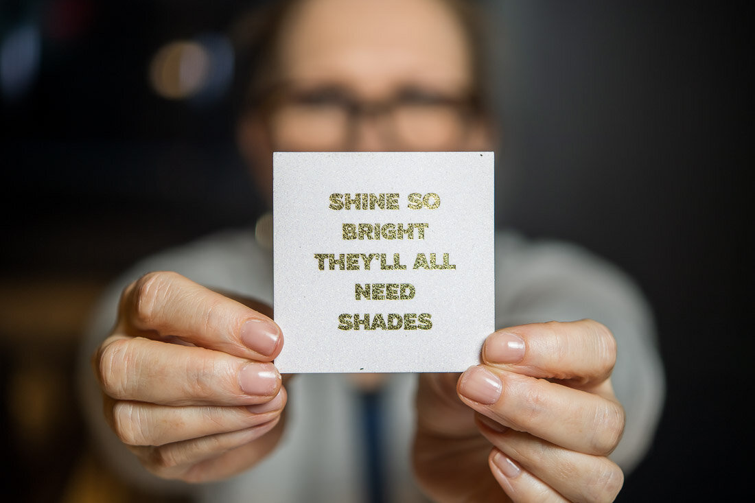 NYC personal branding photography Speaker Facilitator Jeanne Stafford holding up a positive affirmation card to camera