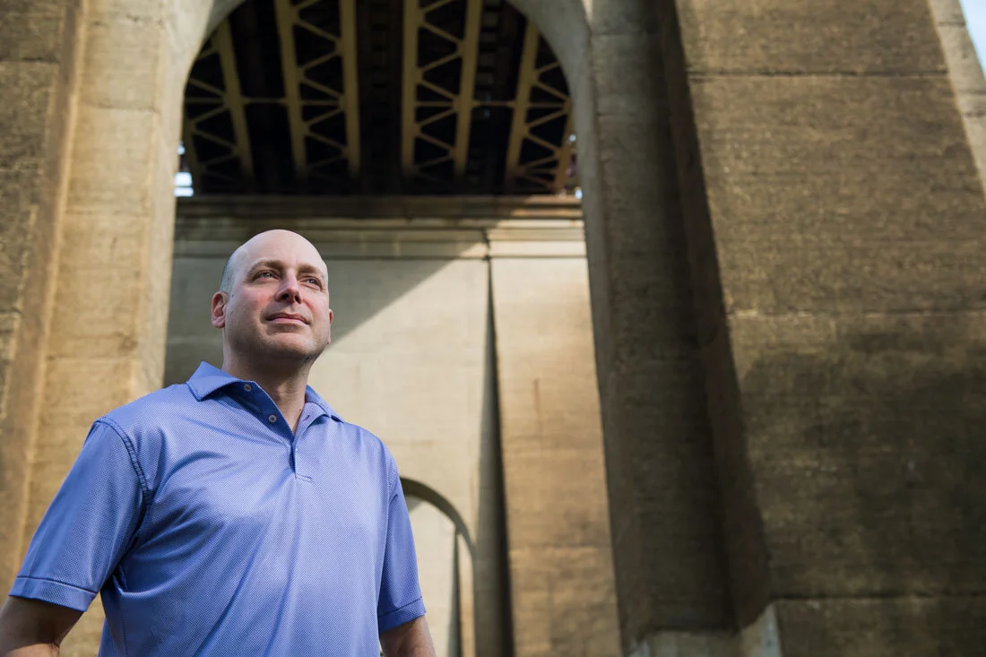 NYC Branded lifestyle portrait Speaker Lou Diamond standing under bridge