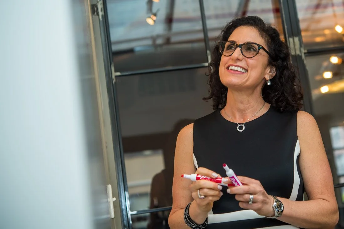 Cascade Leadership Partners Giselle smiling while reading white board