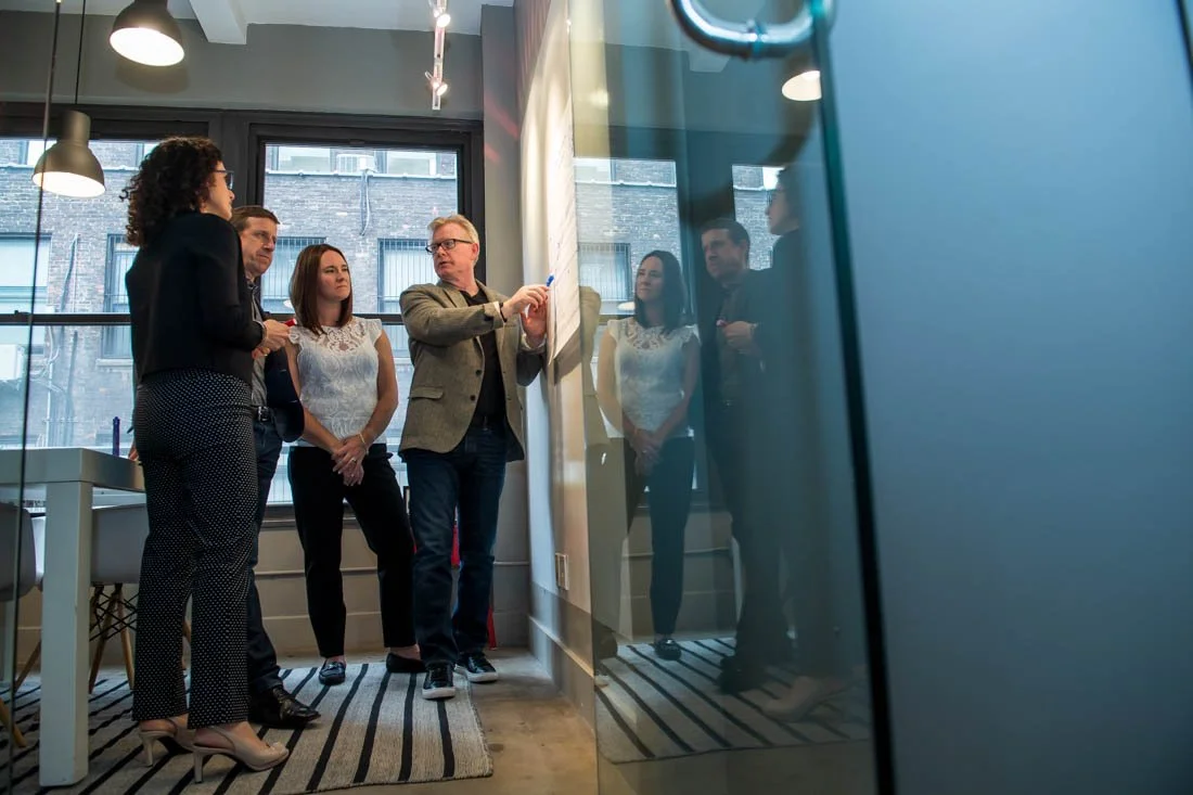 Cascade Leadership Partners Mark writing on white board during team meeting