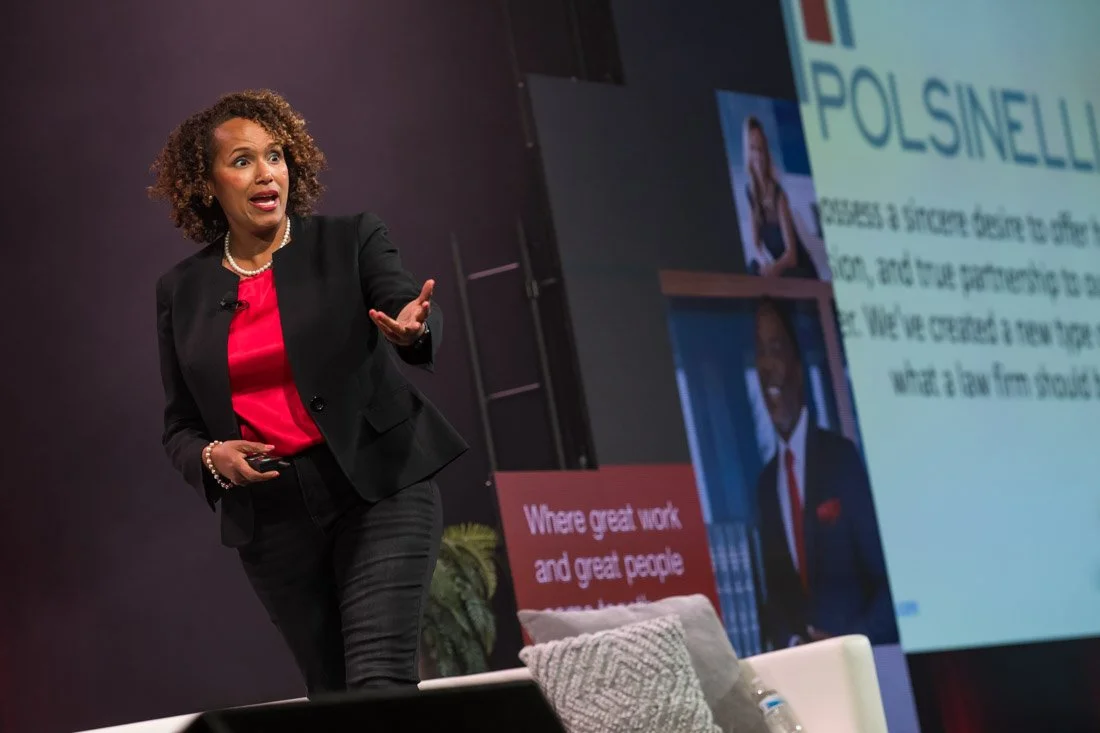 live event photo Speaker Author Heather R Younger walking and talking on stage during keynote