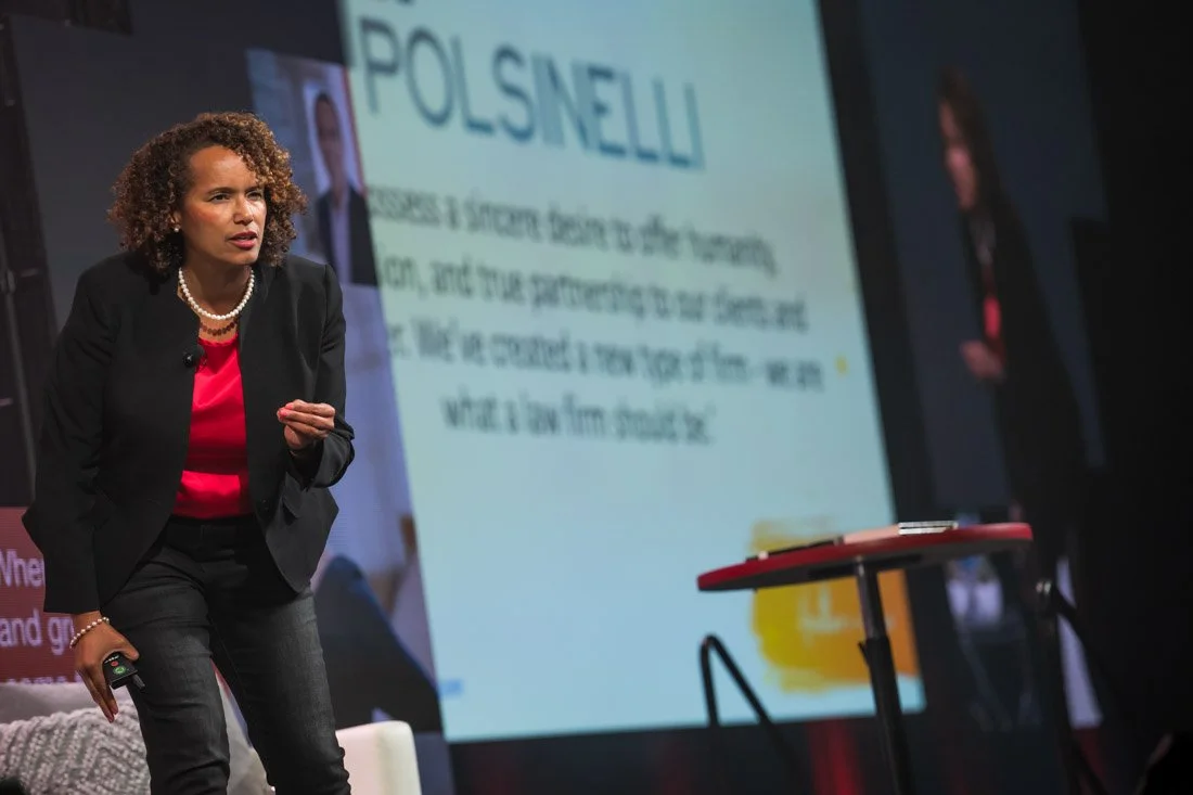 live event photo Speaker Author Heather R Younger leaning towards audience and speaking during keynote