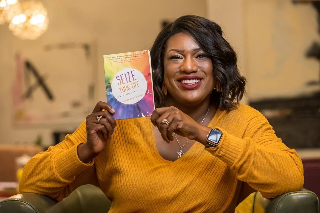 personal branding photo speaker author Jasmine Brett Stringer holding her book in portrait