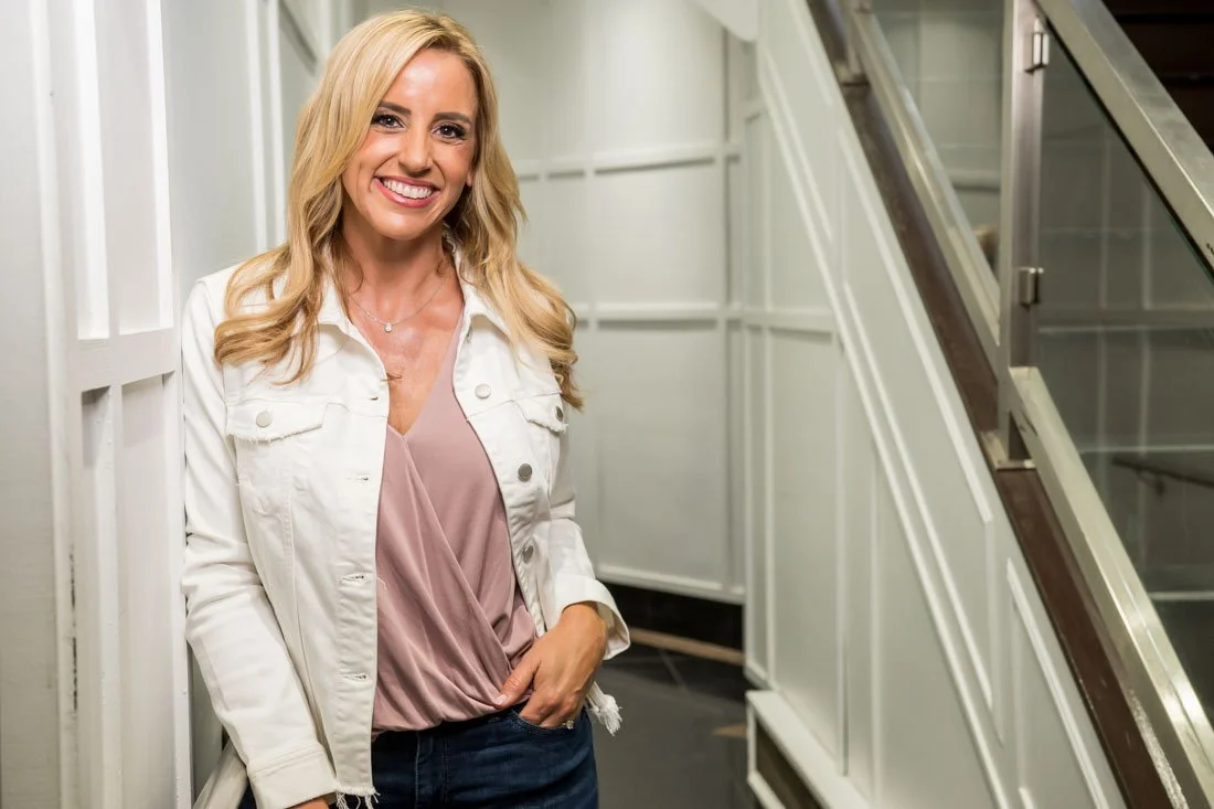 personal brand photo speaker expert Rachel DeAlto leaning against wall smiling