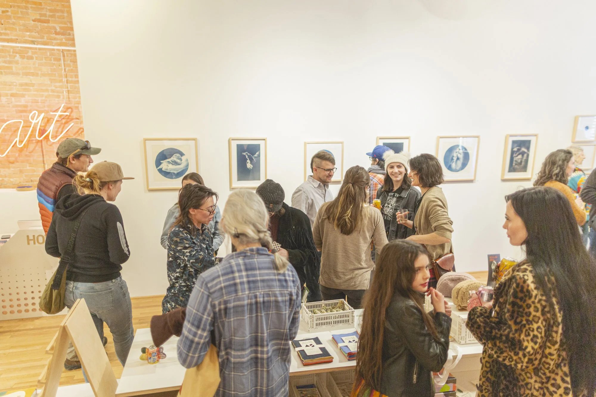 a group of people standing in an art gallery in front of cyanotype photographs