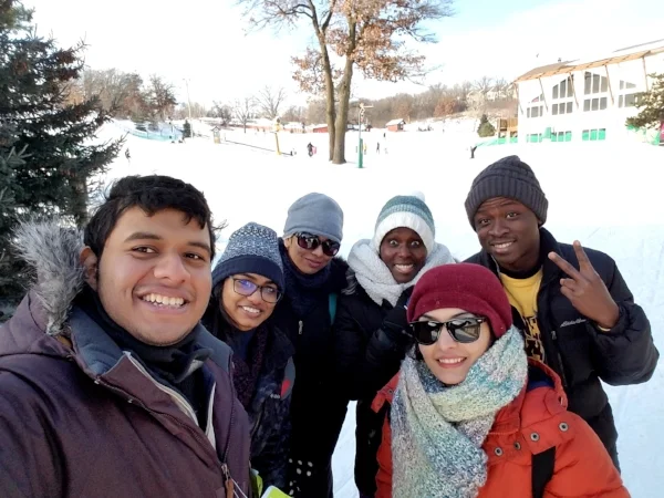 Emmanuel has learned to enjoy Minnesota winters! Here he is with some friends — out on the slopes!